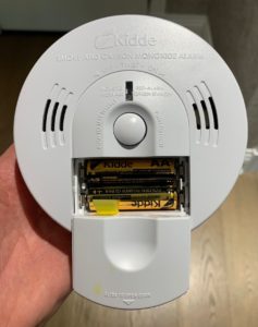 Smoke and carbon monoxide detector front battery compartment